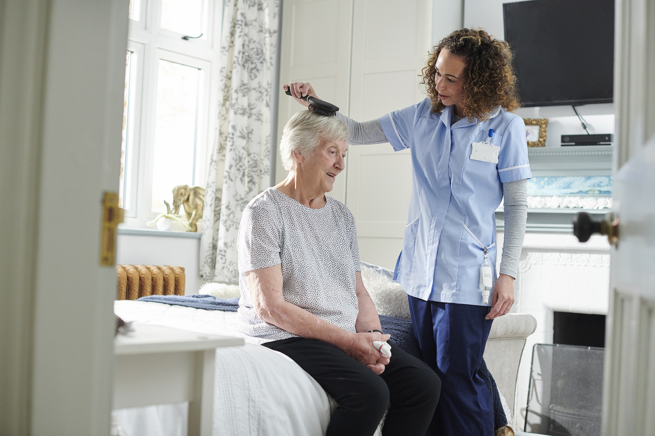 home carer helping senior woman get ready in her bedroom home carer helping senior woman get ready in her bedroom